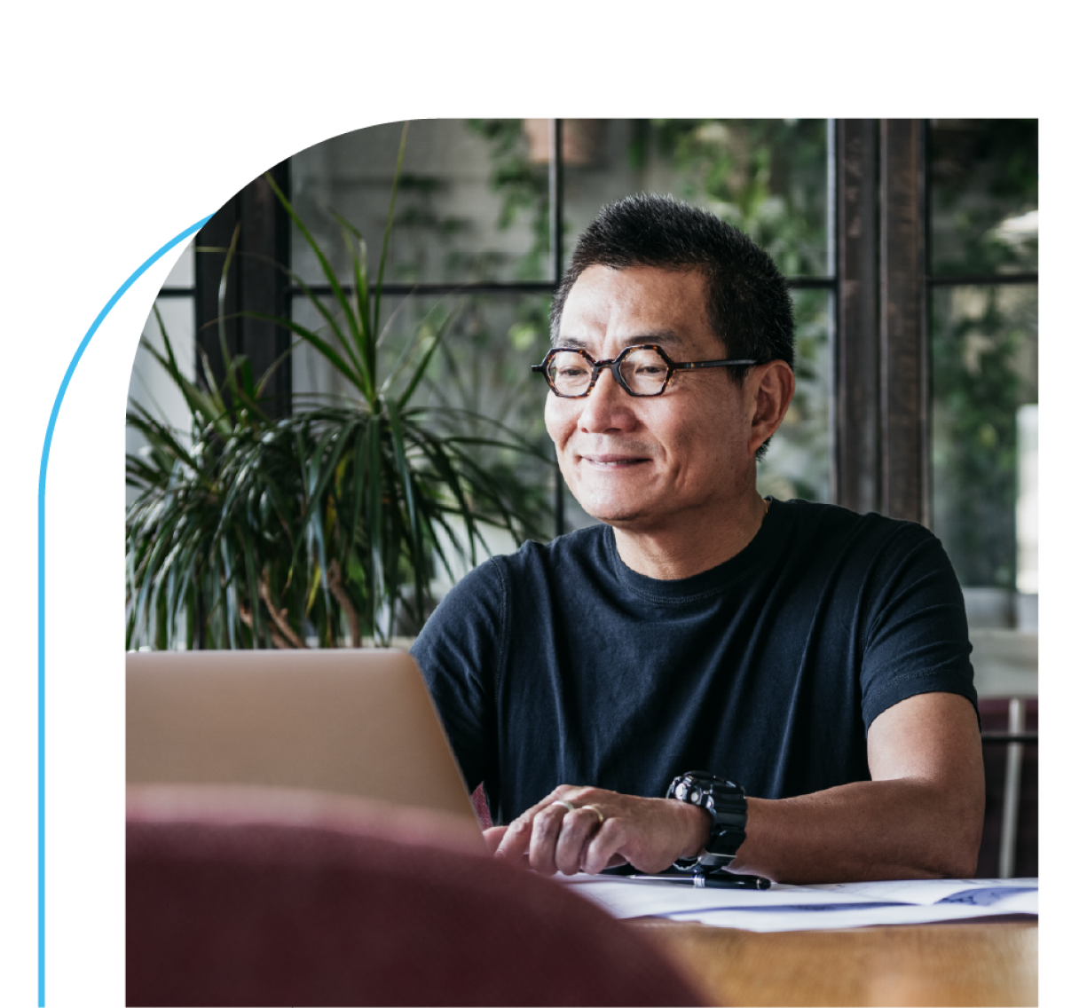 A man working on a laptop with a smile on his face
